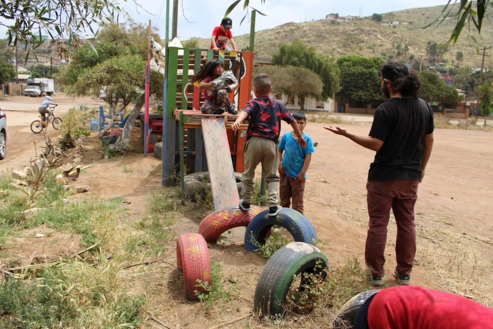 Parque de juegos construido con llantas pintadas y madera recuperada.